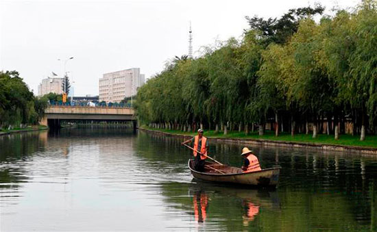 工作人员在流入昆明滇池的河道上准备打捞垃圾和杂物